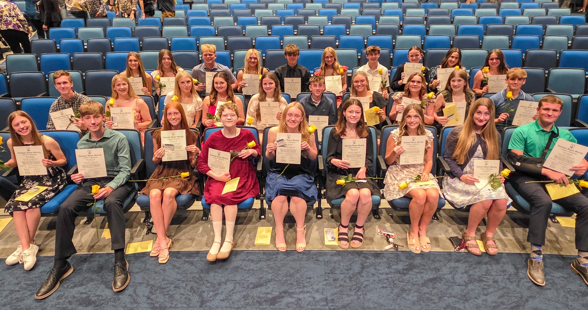 High school students sitting in the auditorium after being recognized as new inductees in the National Honor Society.