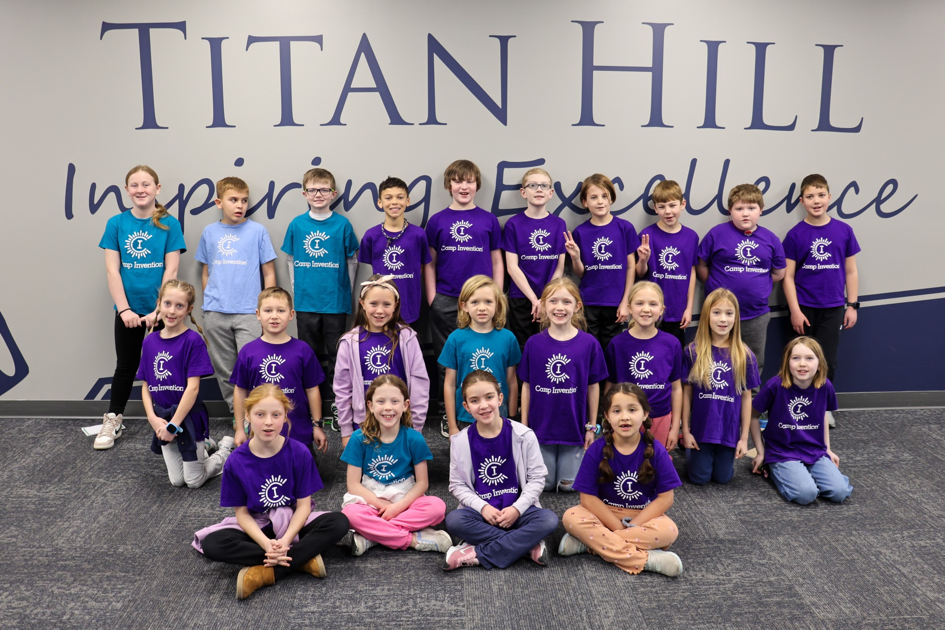 A group of students wearing their Camp Invention t-shirts and posing for National Inventors Day.