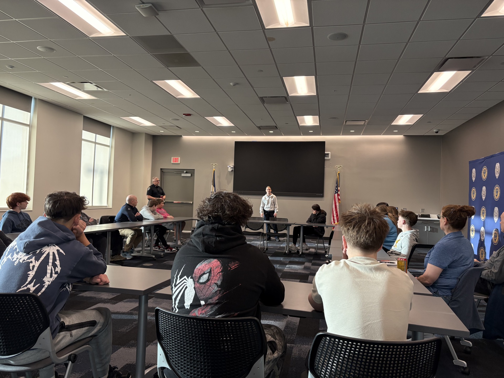 A group of LCHS students sitting in the Council Bluffs Police Department Board Room as an officer talks to the group.