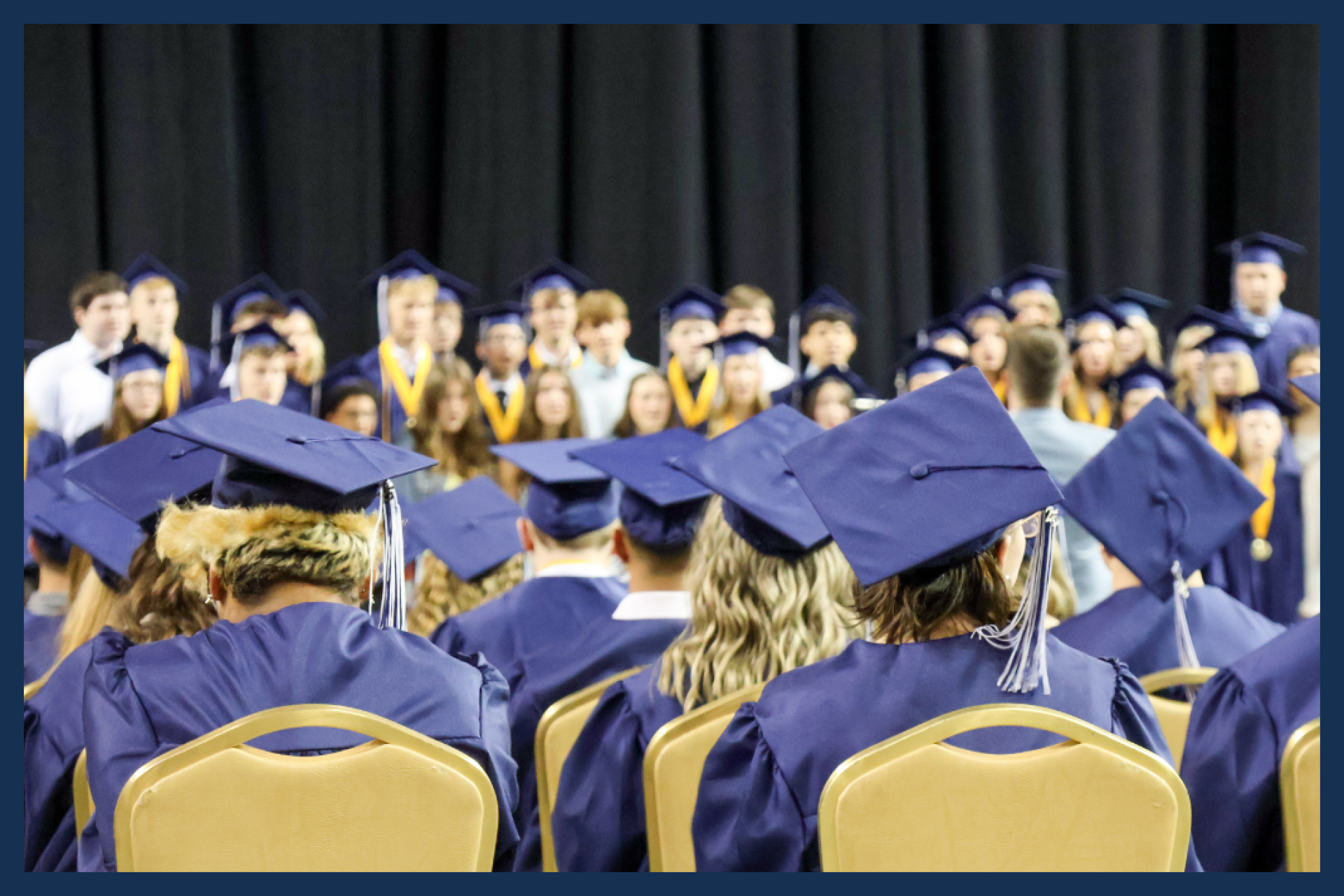 Students at graduation in their caps and gowns.