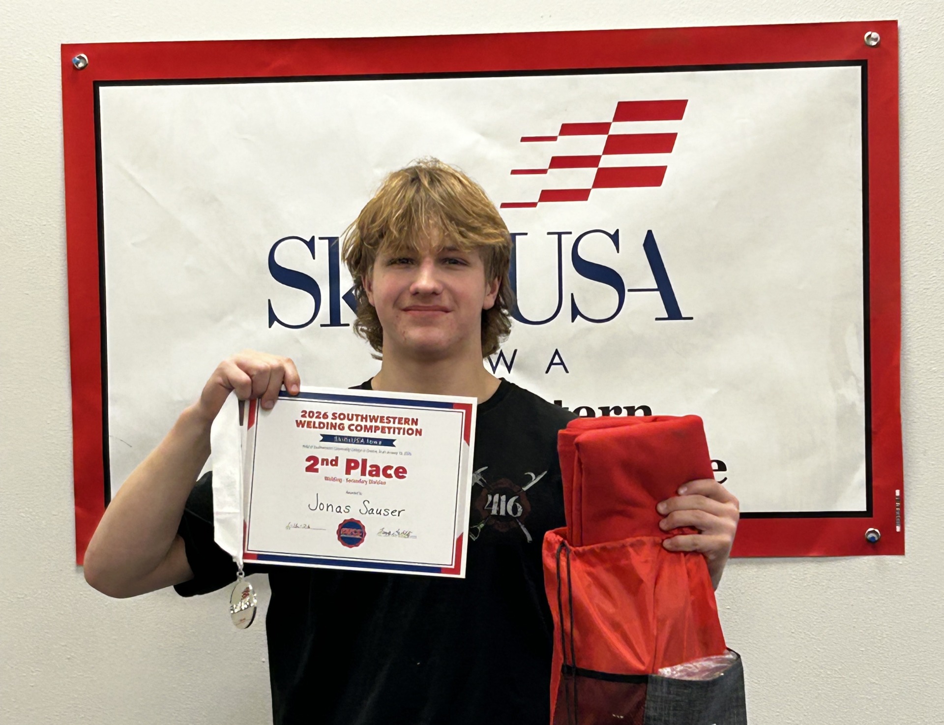 Jonas Sauser, LCHS sophomore, holding his second place award from the SkillsUSA welding competition.