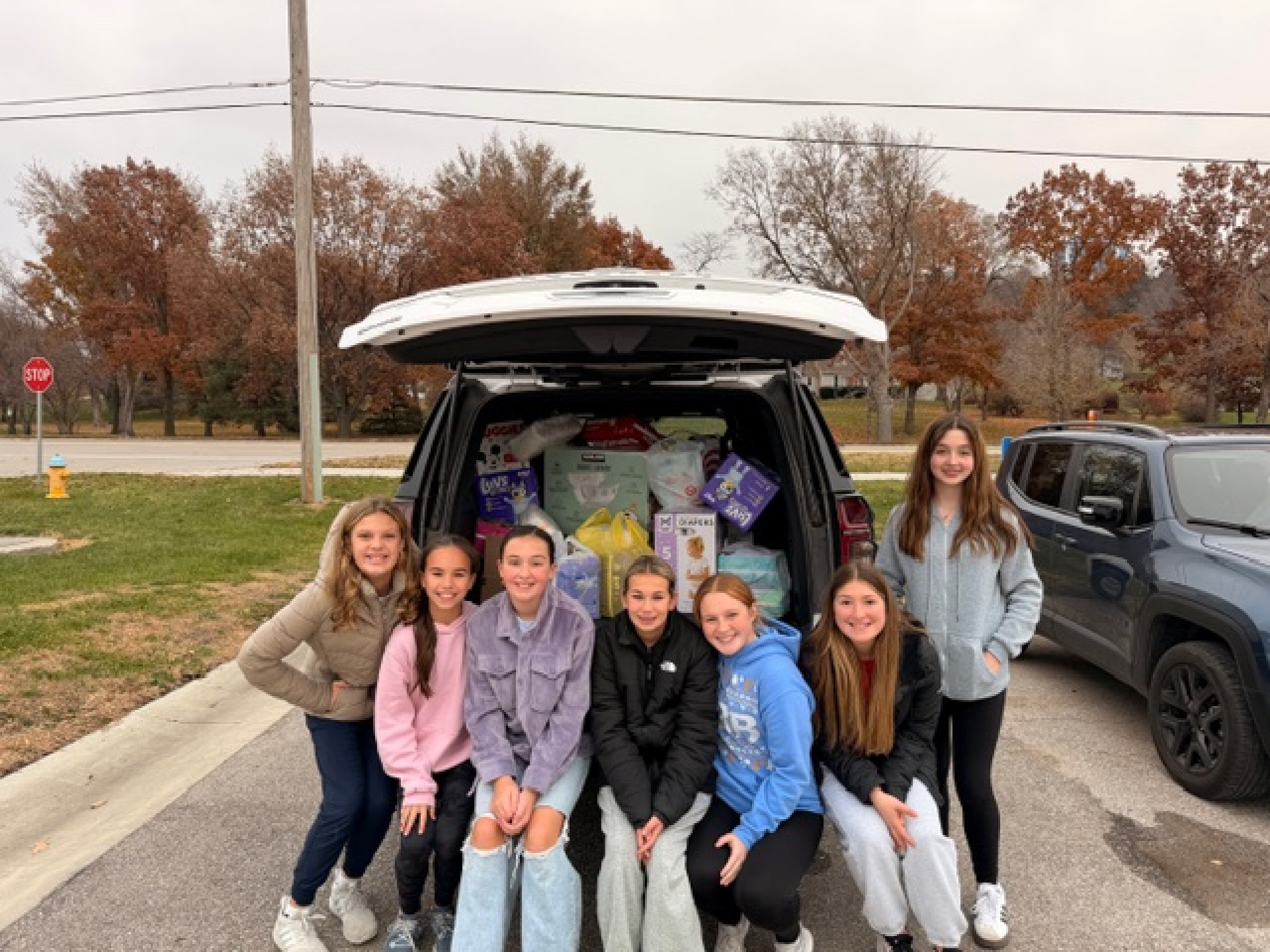 LCMS Student Council students posing with a car full of diapers collected during their Diaper Drive