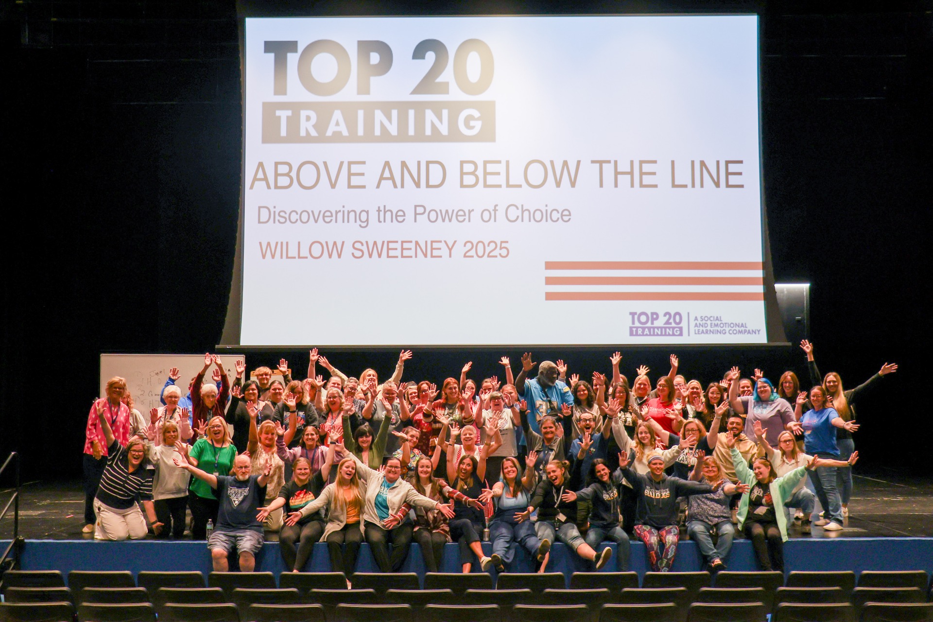 Group photo of over 80 paraeducators on stage