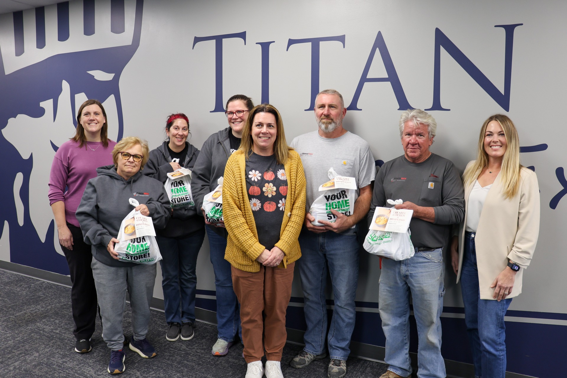 PowerTech employees with Lewis Central employees holding several donated meal kits.