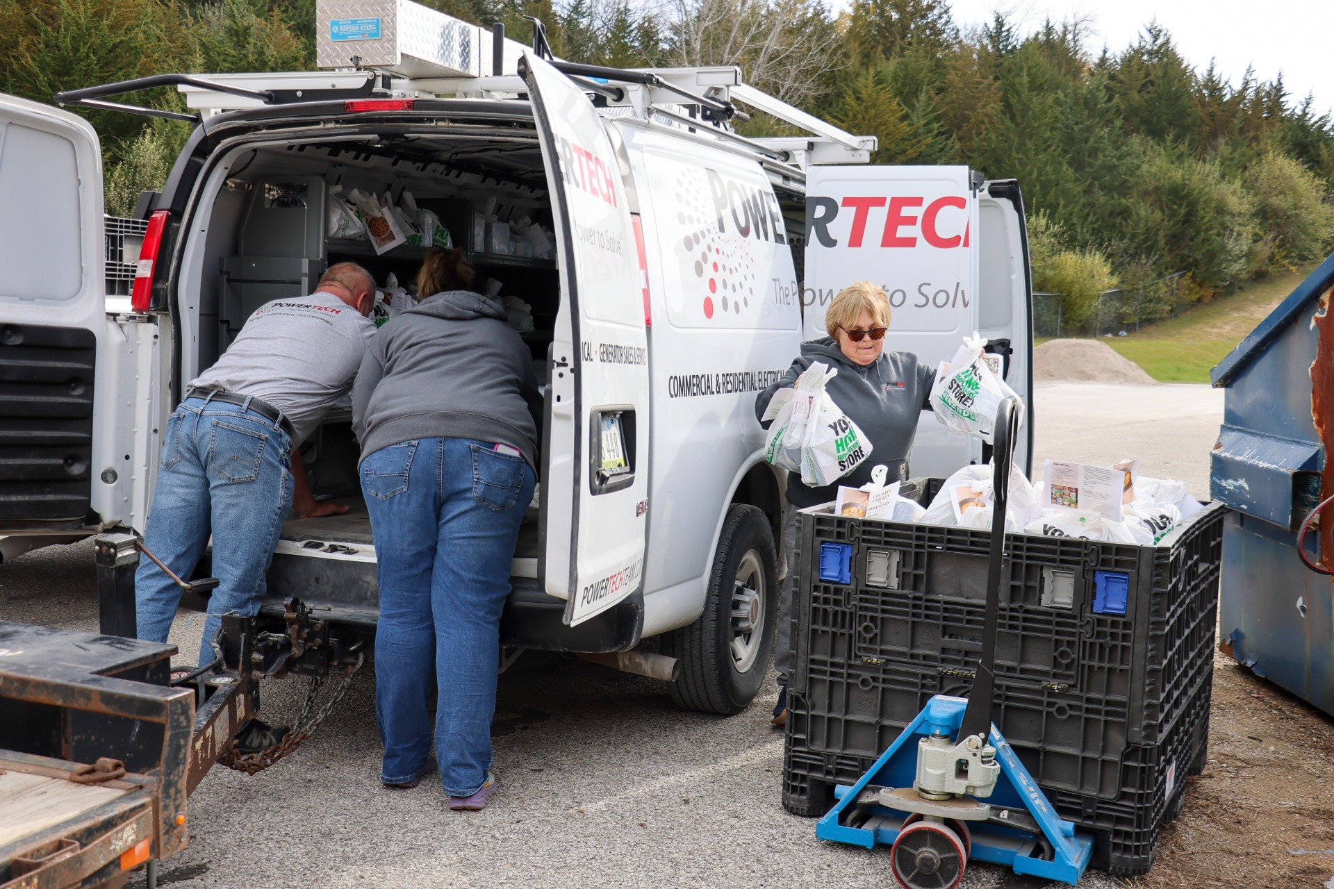 PowerTech employees unloading meal kits from their company vehicle.