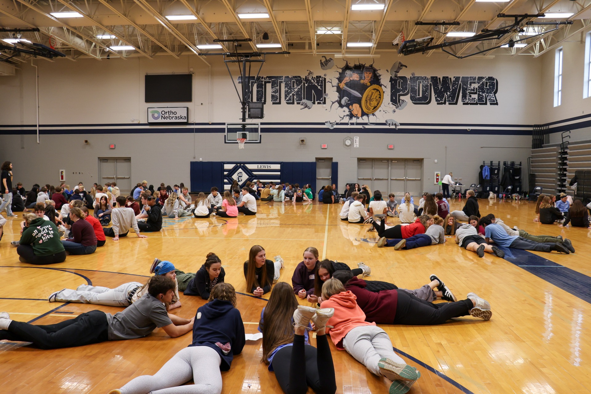 Small groups gathering throughout the gym, talking to each other during the sophomore respect retreat.