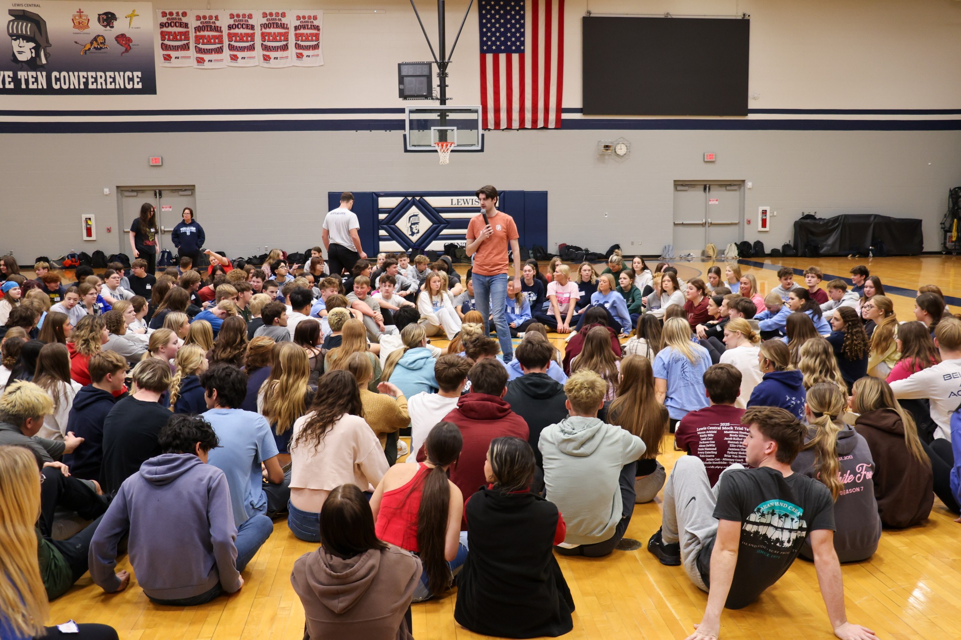The entire sophomore class sitting on the gym floor with the Youth Frontier presenter talking to them.