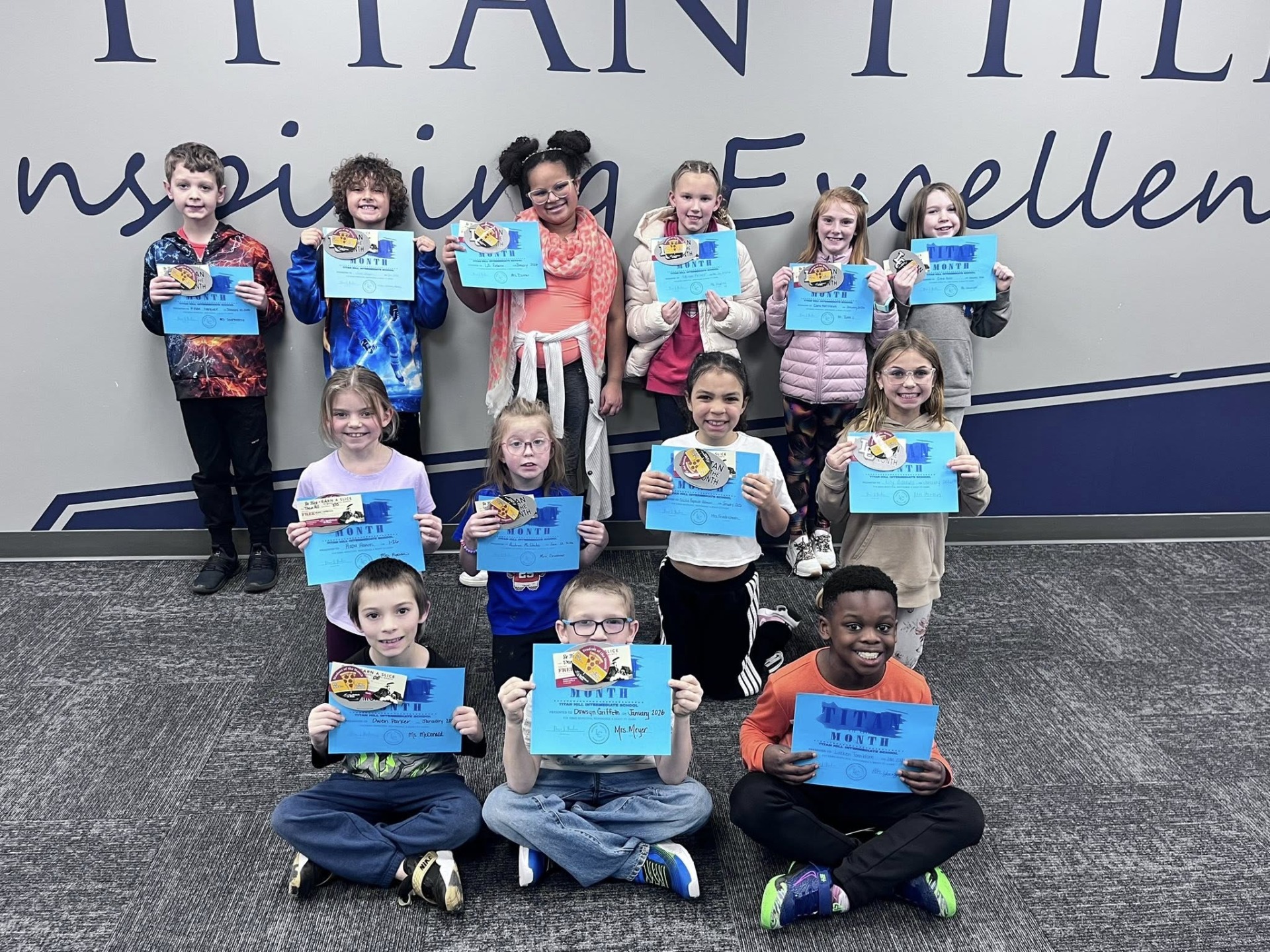 A group of students holding their "Titan of the Month" certificate.