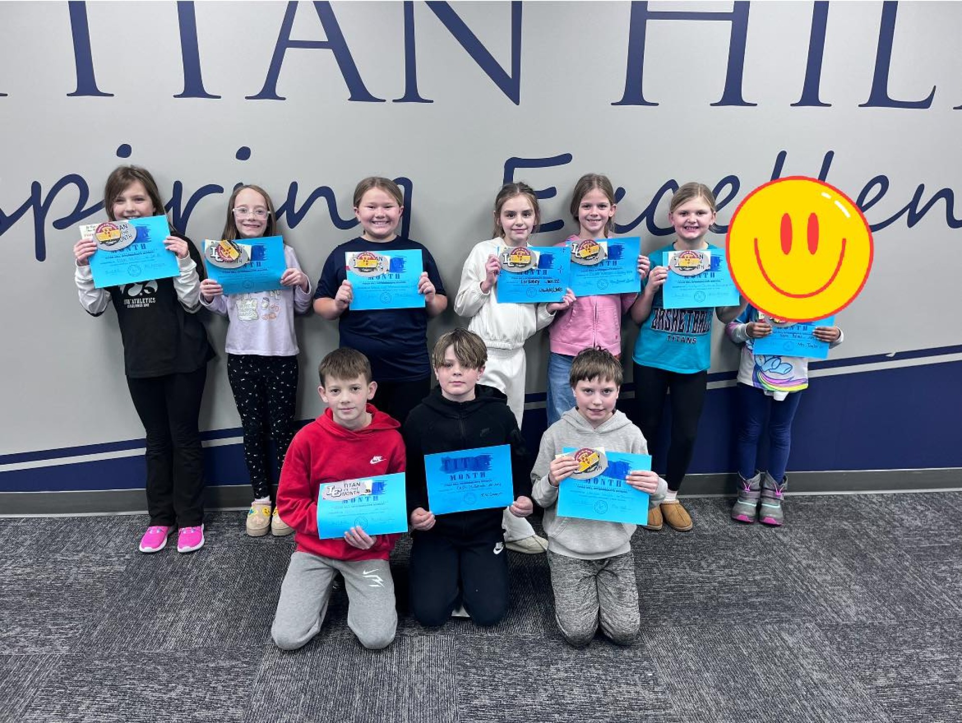 A group of students holding their "Titan of the Month" certificate.
