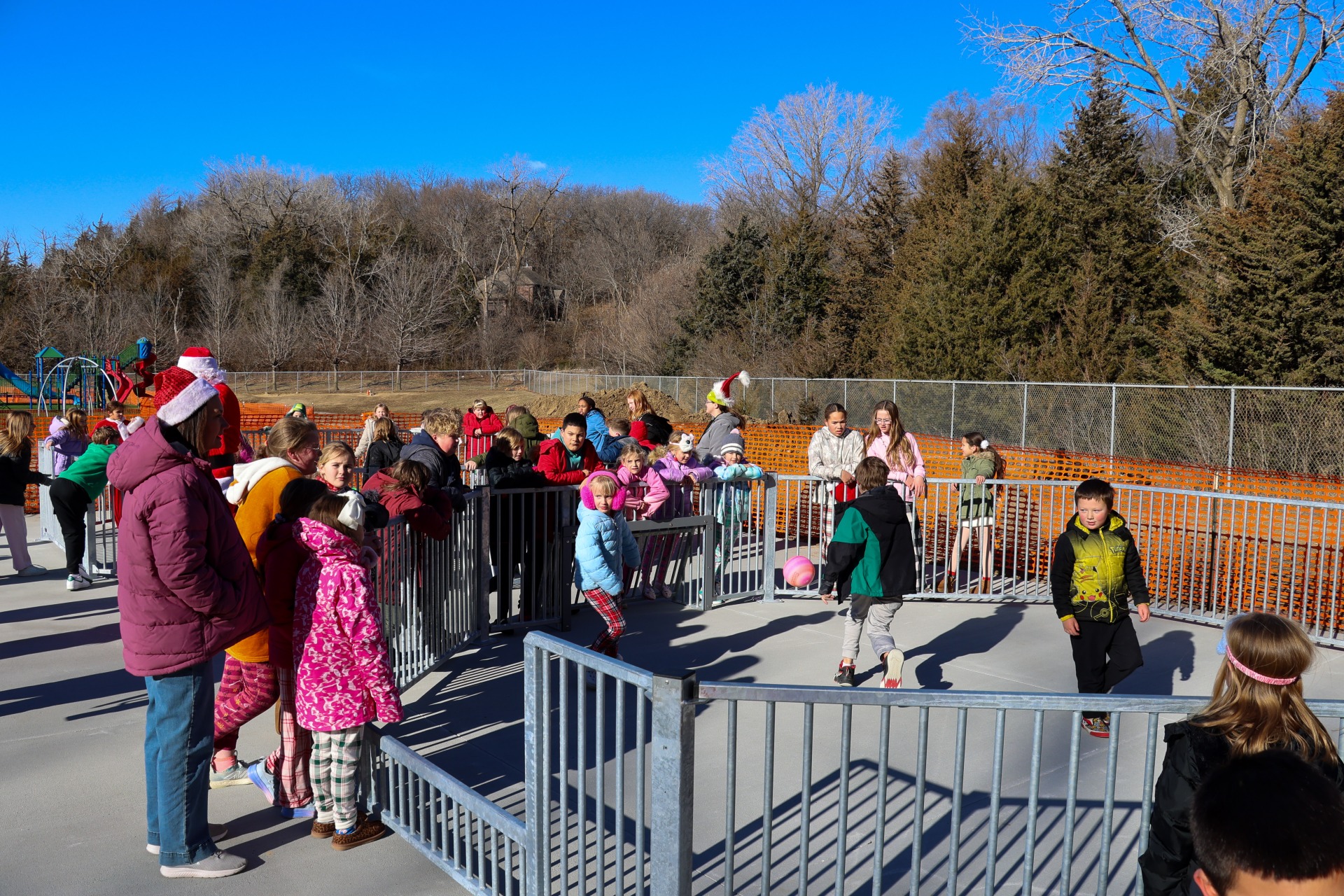 Two new year-round concrete gaga ball pits filled with students playing and observing.