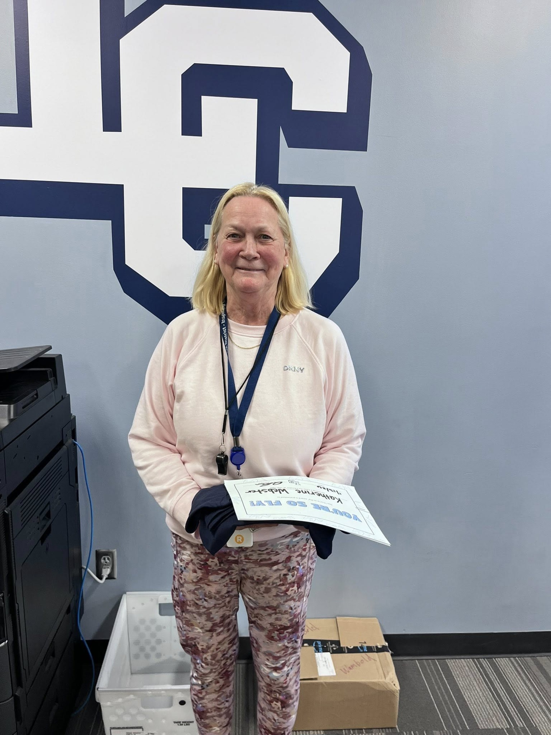 Ms. Webster posing with her "You\'re So Fly" staff award.